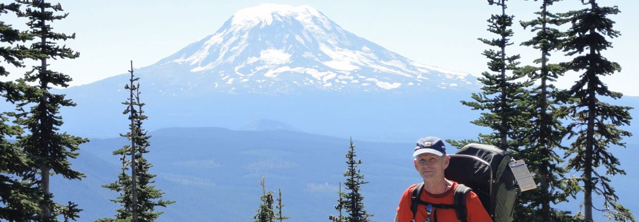 A man hiking with a mountain in the back